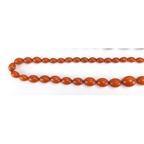 793 - Two amber coloured bead necklaces and a cornelian bead necklace, the largest 80cm in length, approxi... 