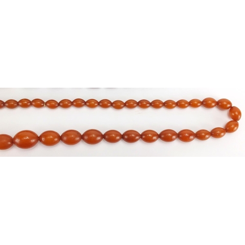 793 - Two amber coloured bead necklaces and a cornelian bead necklace, the largest 80cm in length, approxi... 