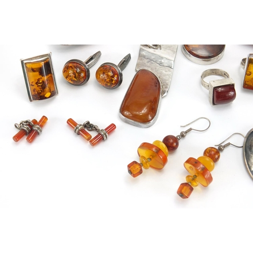 795 - Mostly unmarked silver and natural amber jewellery, including earrings, rings and pendants, the larg... 