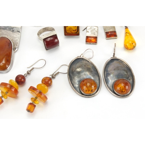 795 - Mostly unmarked silver and natural amber jewellery, including earrings, rings and pendants, the larg... 