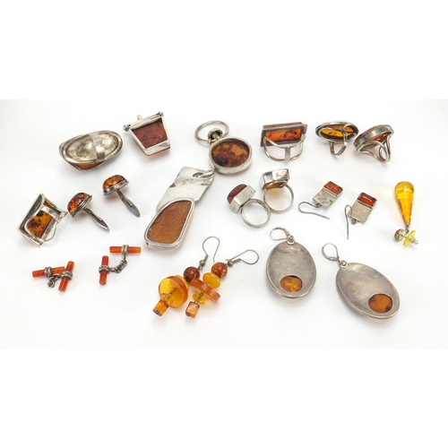 795 - Mostly unmarked silver and natural amber jewellery, including earrings, rings and pendants, the larg... 