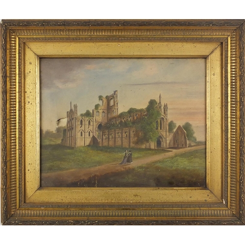 1191 - Two figures walking before the ruins of Whitby Abbey, 19th century oil on canvas, bearing an indisti... 