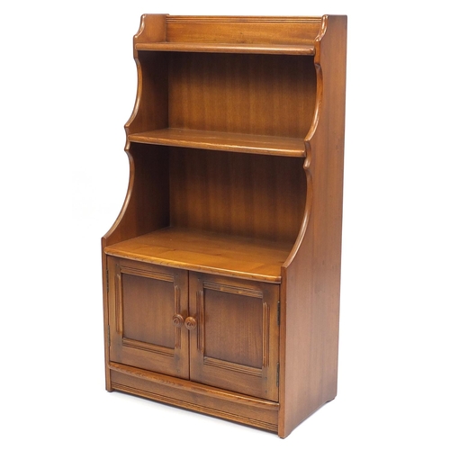 2052 - Ercol waterfall bookcase with cupboard door base, 111cm H x 61cm W x 33cm D