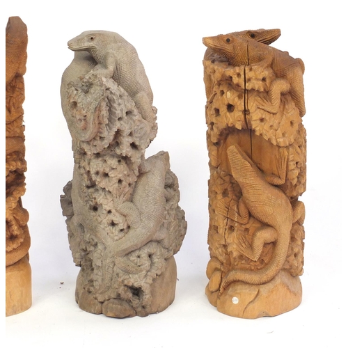 165 - Four carved wood lizard groups, the largest 60cm high