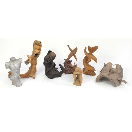 624 - Wooden carvings including surreal figures and dolphins, the largest 73cm high