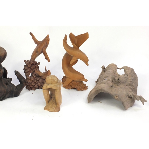 624 - Wooden carvings including surreal figures and dolphins, the largest 73cm high