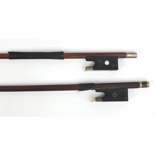 246 - Ebonised walking cane with silver handle, a horn walking cane and two violin bows