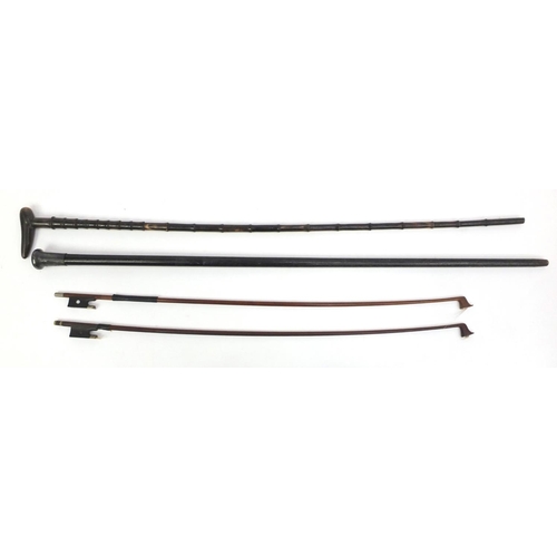 246 - Ebonised walking cane with silver handle, a horn walking cane and two violin bows