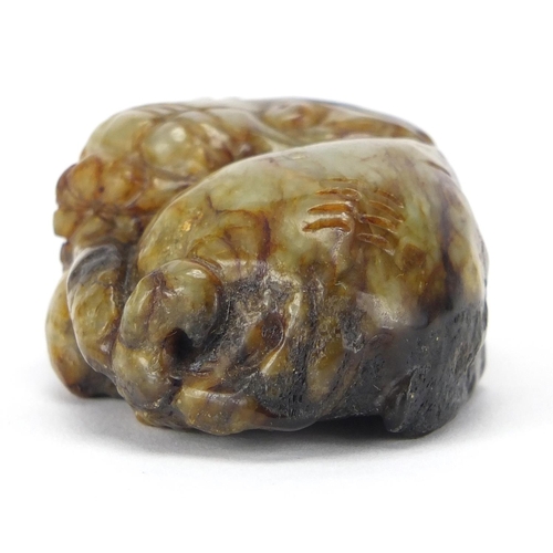 422 - Chinese russet and green jade carving of a Buddhistic lion, 6cm wide