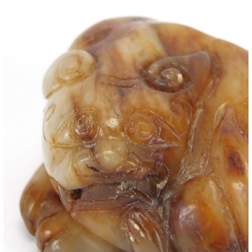 423 - Chinese russet and white jade carving of a mythical lion, 6cm wide