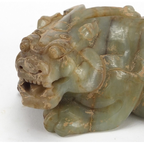 420 - Large Chinese green and russet jade carving of a crouching mythical lion, 13cm wide