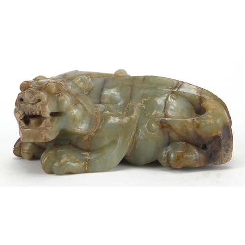 420 - Large Chinese green and russet jade carving of a crouching mythical lion, 13cm wide