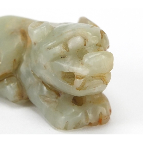 426 - Two Chinese green and russet jade carvings of recumbent lions, the largest 5.5cm wide