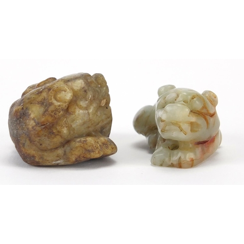 426 - Two Chinese green and russet jade carvings of recumbent lions, the largest 5.5cm wide