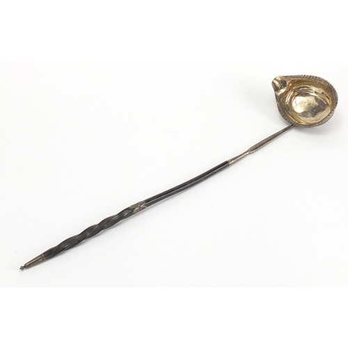 672 - Unmarked Georgian silver ladle with twisted horn handle, 40cm in length