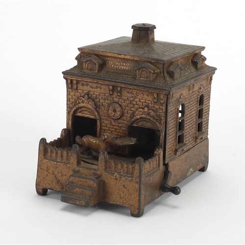 327 - Novelty cast iron money box in the form of a dog rotating in and out of a house, 14cm in length