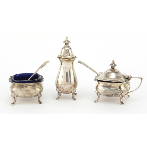 650 - Silver three piece cruet, the mustard and salt with blue glass liners, HM Birmingham 1928, the large... 