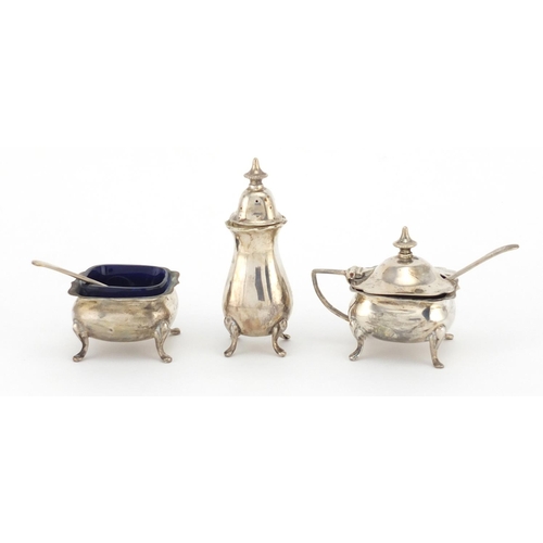 650 - Silver three piece cruet, the mustard and salt with blue glass liners, HM Birmingham 1928, the large... 