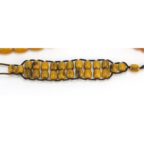 779 - Two amber coloured bead necklaces and a bracelet, the largest 70cm in length, approximate weight 99.... 