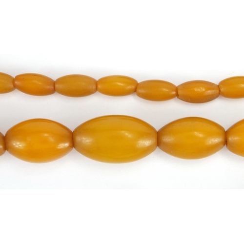 779 - Two amber coloured bead necklaces and a bracelet, the largest 70cm in length, approximate weight 99.... 