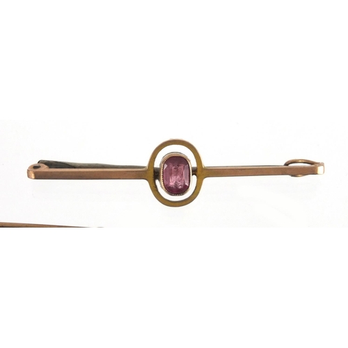 767 - Three 9ct gold bar brooches, one set with a green shell and one with a Garnet, the largest 6.5cm in ... 