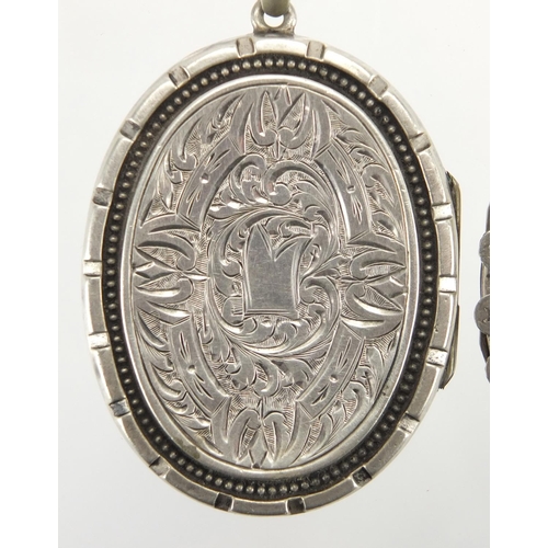 762 - Victorian silver locket engraved with flowers and birds and one other, the largest 5.5cm in length, ... 