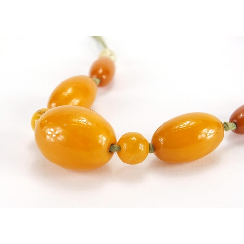 780 - Butterscotch amber coloured bead necklace, the largest bead 3cm in length,  approximate weight 34.0g