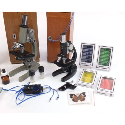 96 - Three microscopes together with a collection of prepared slides, all with cases