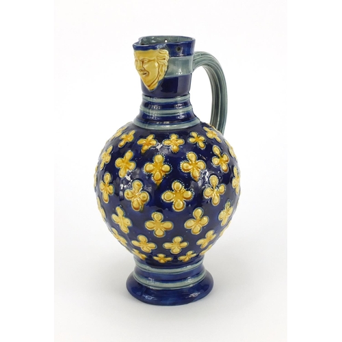 576 - Minton's Majolica jug with mask spout hand painted with flowers, impressed factory marks and numbere... 