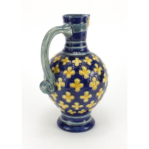 576 - Minton's Majolica jug with mask spout hand painted with flowers, impressed factory marks and numbere... 