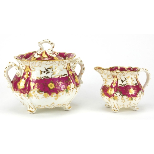 513 - Victorian Rockingham creamer and lidded sucrier, each hand painted and gilded with flower heads and ... 