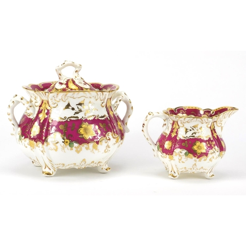 513 - Victorian Rockingham creamer and lidded sucrier, each hand painted and gilded with flower heads and ... 