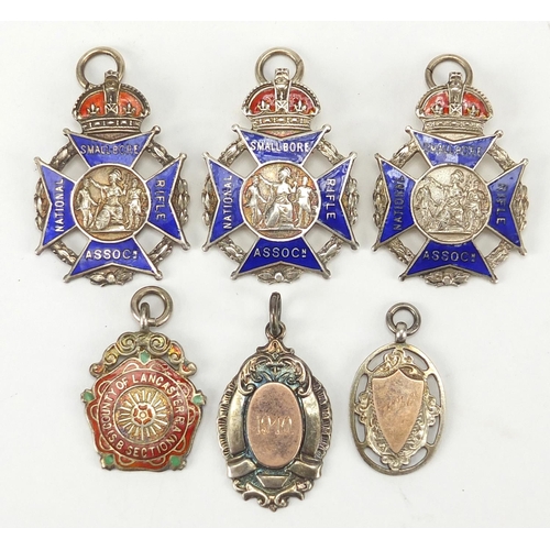 281 - Six Military interest silver jewels including three National Rifle Association enamel examples, the ... 