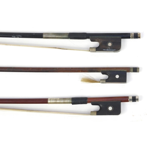 141 - Four old wooden violin bows including an ebonised example each with Mother of Pearl frogs, one indis... 