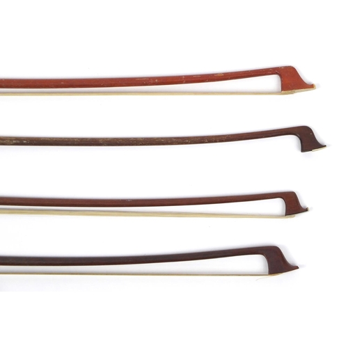 144 - Seven wooden violin bows, some with Mother of Pearl frogs, the largest 58cm in length