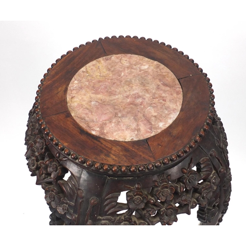 393 - Chinese hardwood plant stand with inset marble top, carved with flower heads, 92cm high