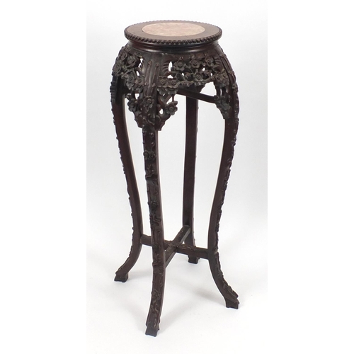 393 - Chinese hardwood plant stand with inset marble top, carved with flower heads, 92cm high