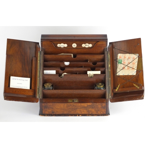 103 - Victorian walnut stationery box, the sloped front opening to reveal a letter rack and day date calen... 