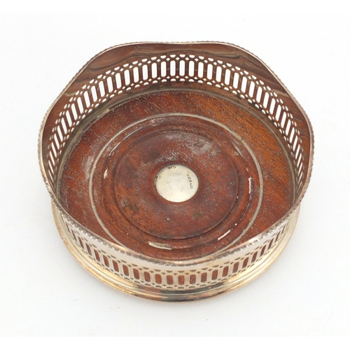 657 - Circular silver and oak wine coaster with pierced decoration, R & D Birmingham 1989, 14cm in diamete... 