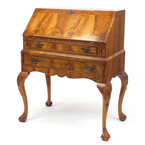2014 - Mahogany bureau with feather banded fall, enclosing a fitted interior, above two drawers on cabriole... 