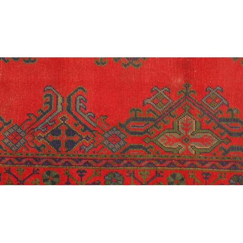 2030 - Rectangular Turkish Oushak rug, having a stylised floral design onto a red ground, 215cm x 178cm