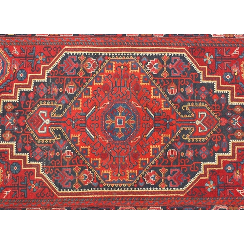 2059 - Rectangular North West Persian rug having an all over geometric and floral design onto a red ground,... 