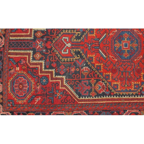 2059 - Rectangular North West Persian rug having an all over geometric and floral design onto a red ground,... 