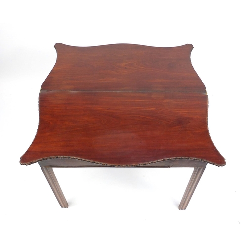 26 - Mahogany folding serving table with serpentine outline, 70cm high x 90cm wide