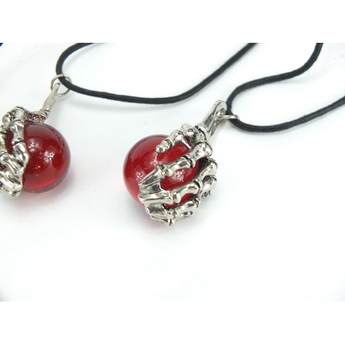 403 - Seven Gothic skeleton hand and ball pendants on rope necklaces