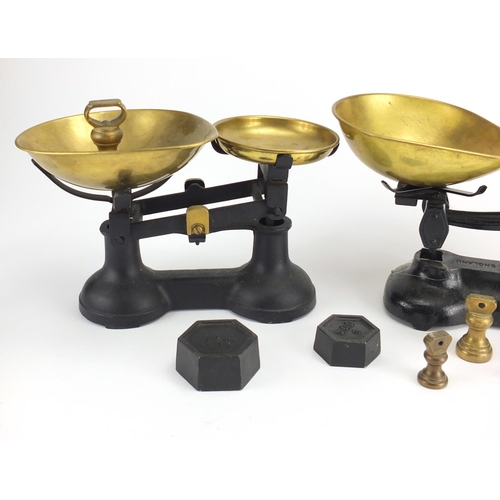 498 - Two sets of cast iron scales with brass pans and weights, including Libra