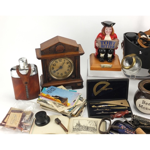 664 - Box of objects including a mantel clock, Toby Bitter advertising figure, postcards and a pair of bin... 