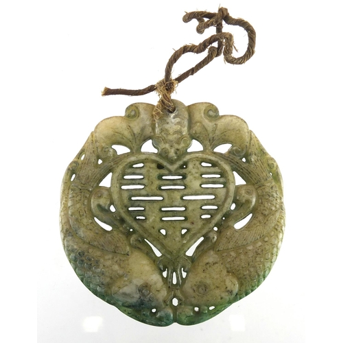 653 - Chinese carved stone pendant, decorated with fish, 6.5cm in diameter