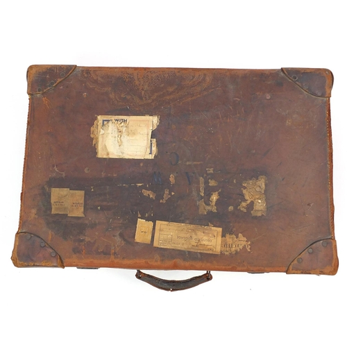 83 - Vintage brown leather suitcase, with some paper shipping labels, 62cm in length