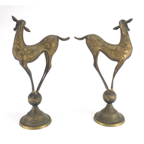 568 - Pair of stylised brass deer's, engraved with flower heads and foliage, each 50cm high